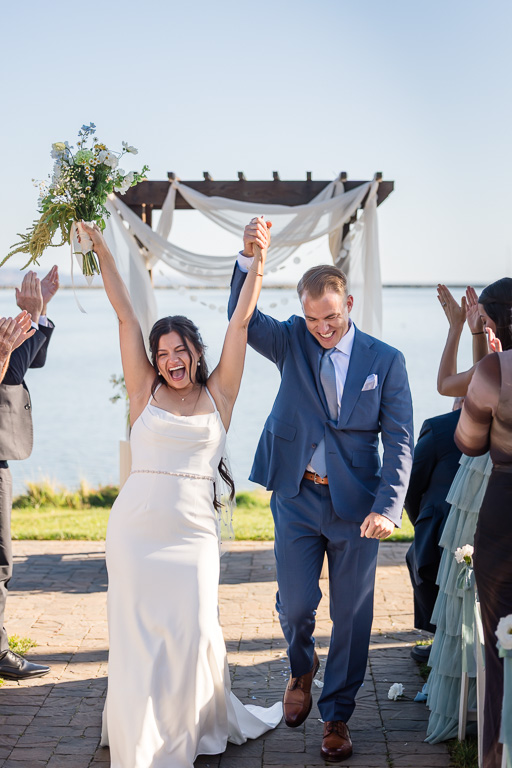 bride and groom very cheerfully marching back down the aisle after wedding ends