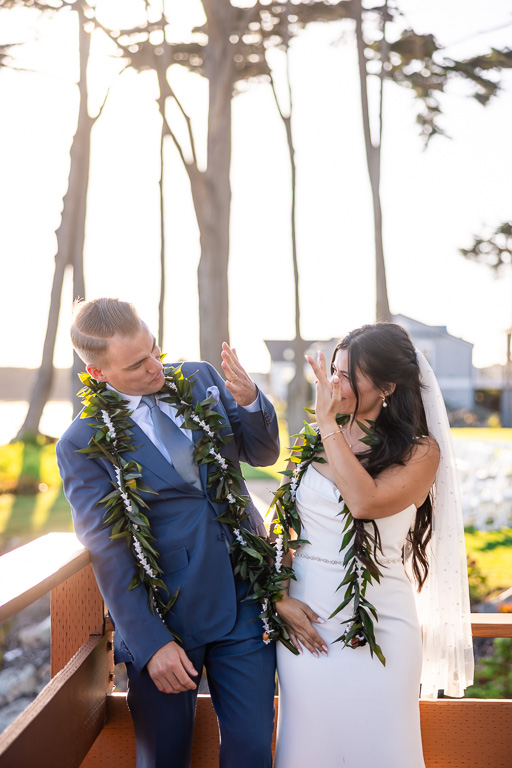 bride and groom showing each other their rings under the golden sunlight