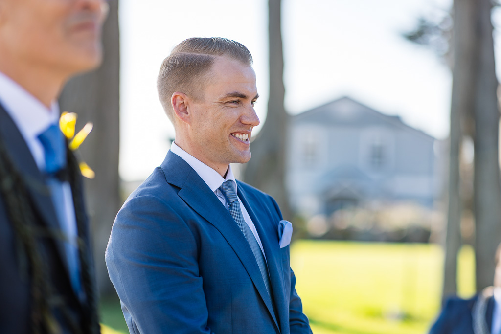 groom happily looking on as his soon-to-be wife arrives