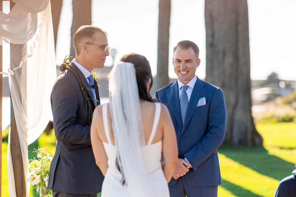 groom happily looking at his bride during the ceremony