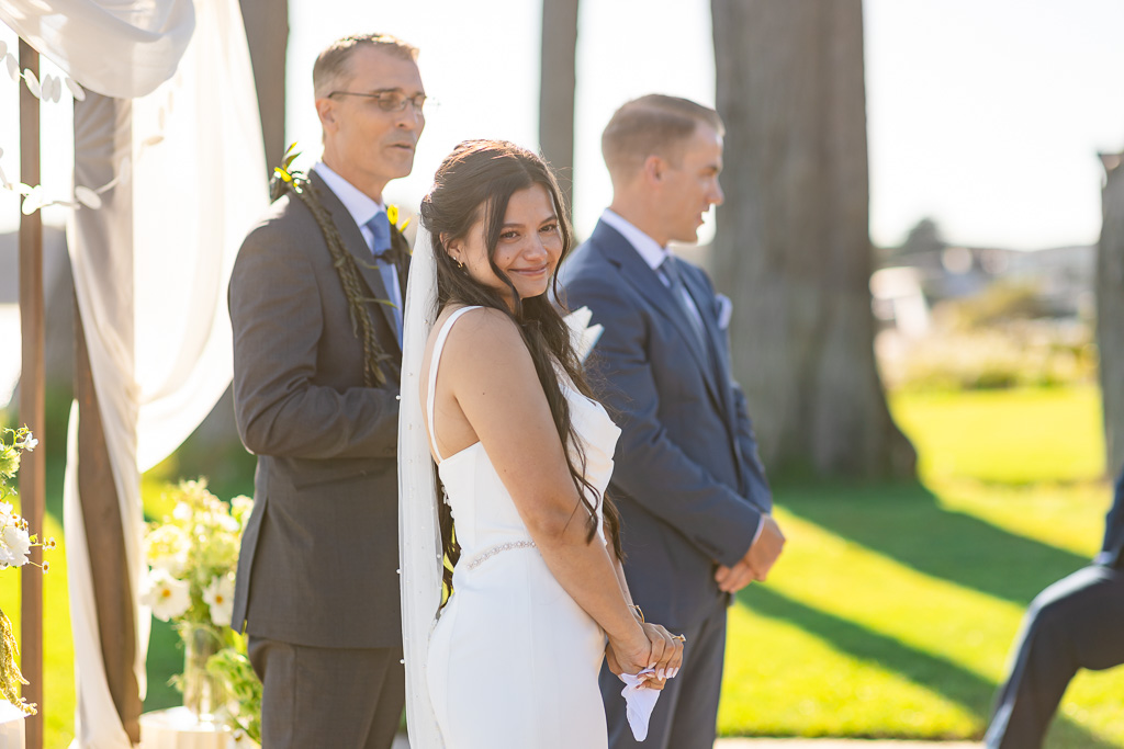 bride and groom looking towards their guests during the ceremony