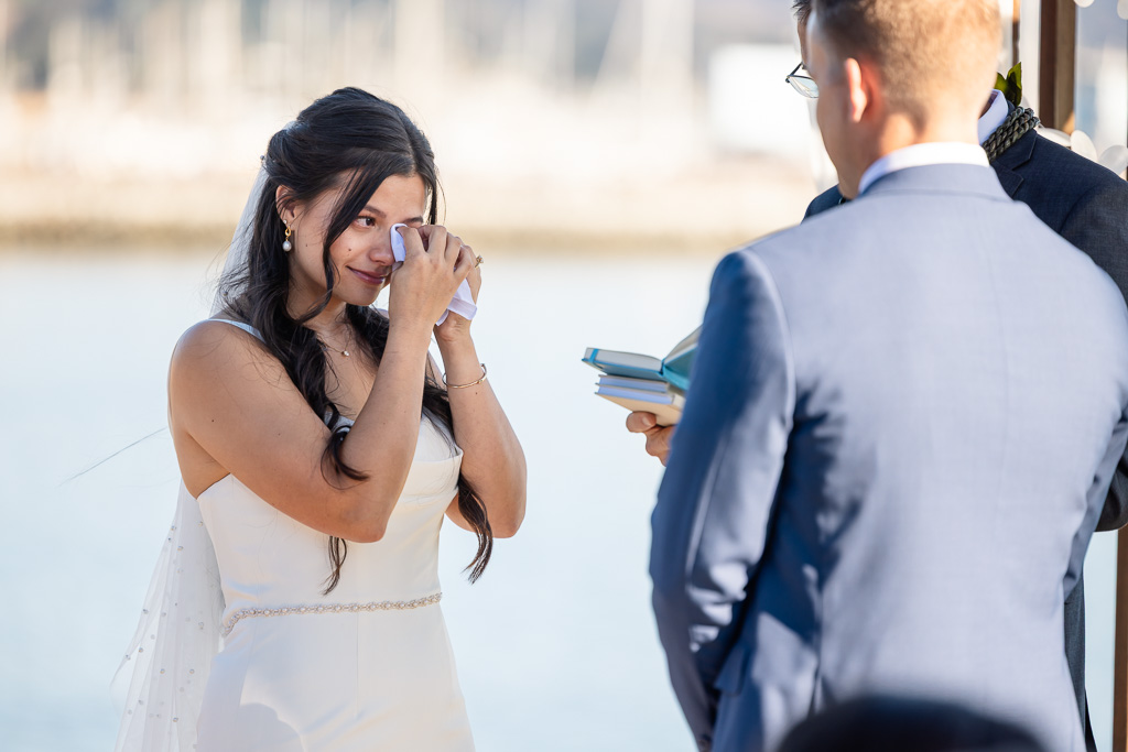 an emotional and tearful moment beautifully captured of the bride wiping away a tear during wedding ceremony