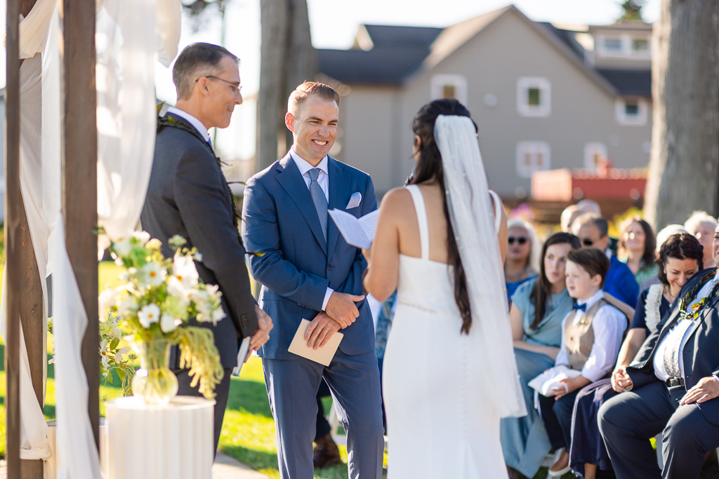 groom listening to his bride reading personal vows
