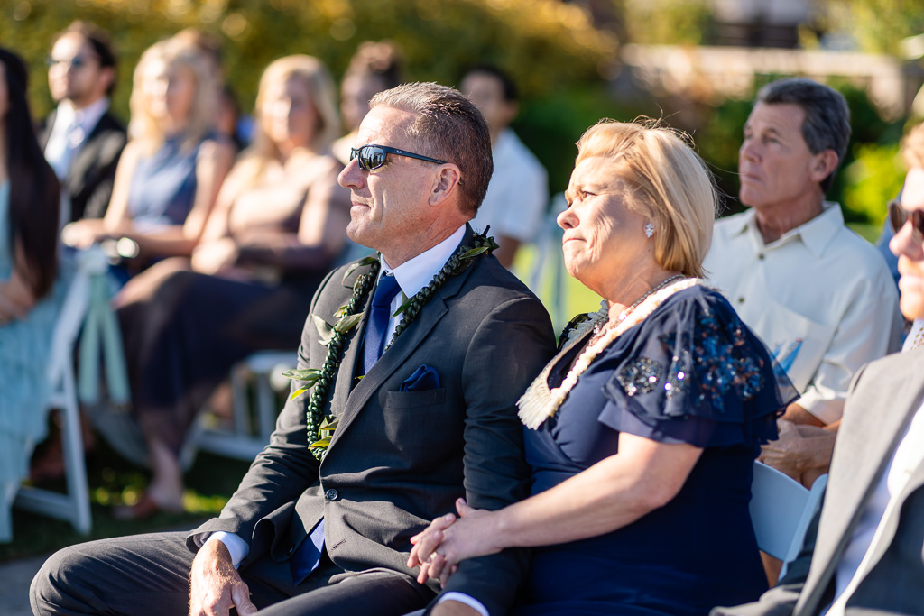 groom's parents looking on as the wedding ceremony commences