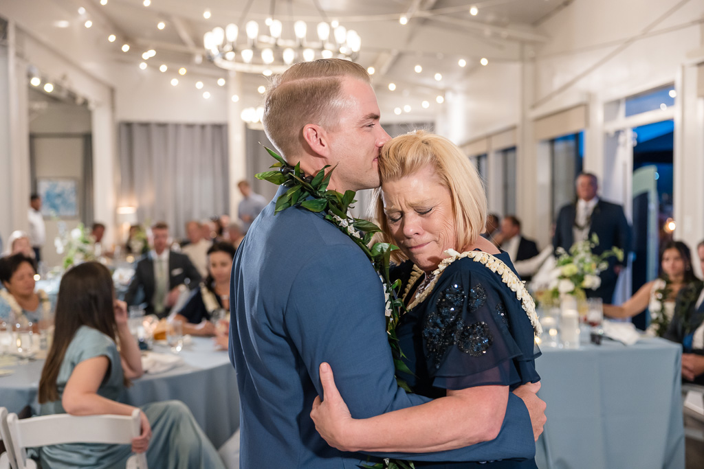 a very emotional moment between the groom and his mother at wedding reception