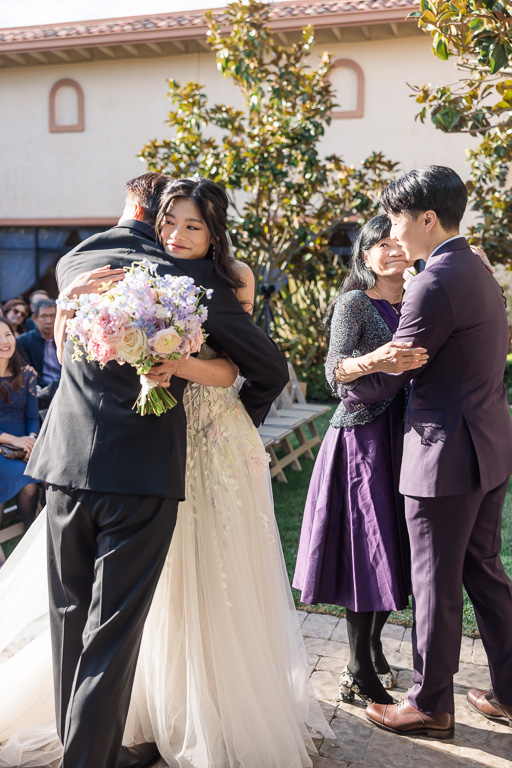 bride hugging her dad at the end of the aisle
