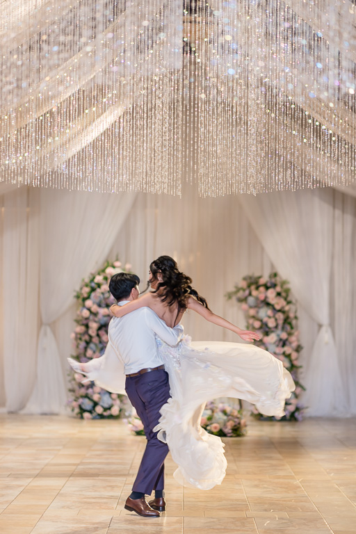 an impressive dance move with the groom picking up the bride and spinning her around