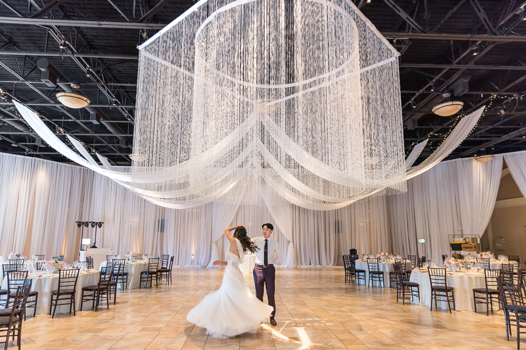 Bride and groom dancing under crystal chandelier at Casa Real Pleasanton winery
