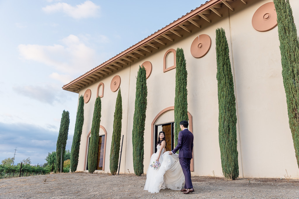 candid moment of the bride and groom walking along the back side of Casa Real