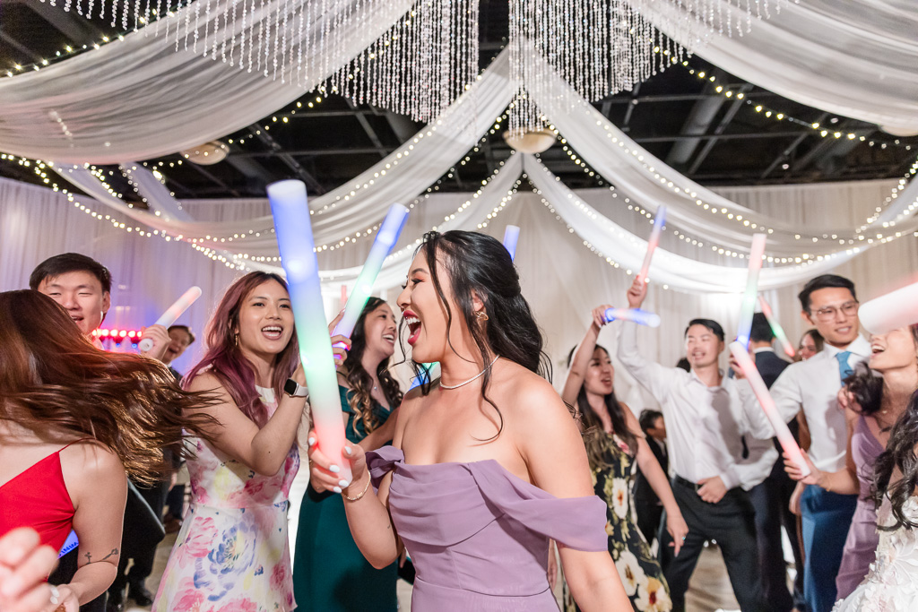 Wedding guests dancing with glow sticks at Pleasanton winery reception