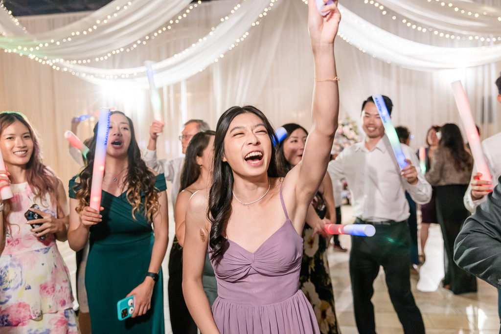 Bridesmaid celebrating with glow stick on the dance floor