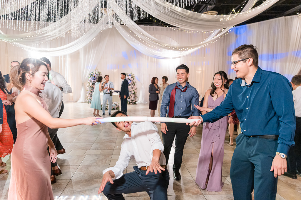 Groom doing limbo game at Casa Real at Ruby Hill wedding reception