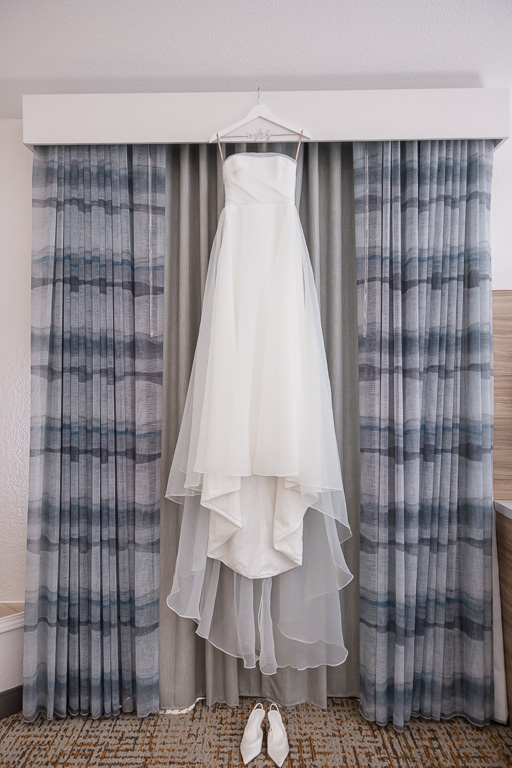 wedding dress hanging up in hotel room