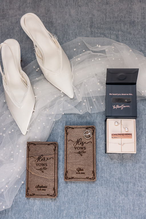 flat lay of wedding details including custom bride/groom vow books