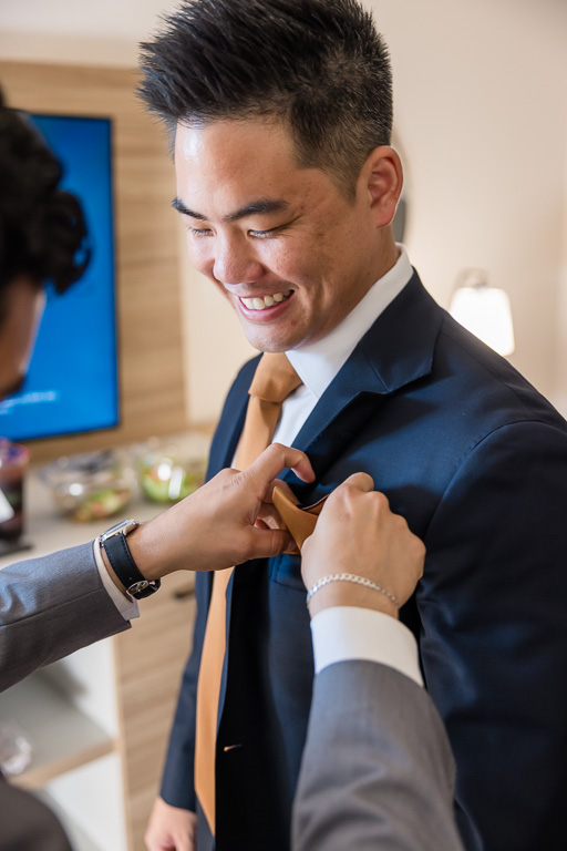 the groom getting his pocket square assembled