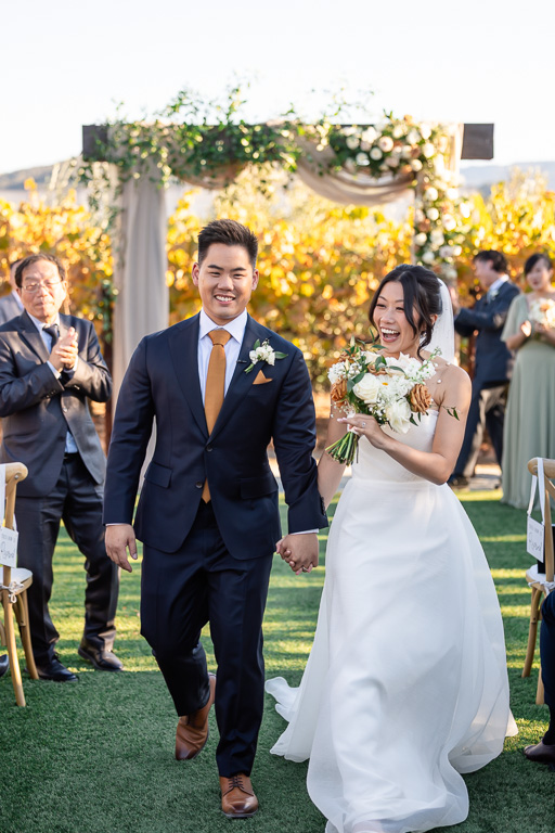 newlyweds happily walking down the aisle