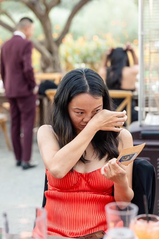 a friend shedding a few tears after looking at the personal gift from the bride and groom