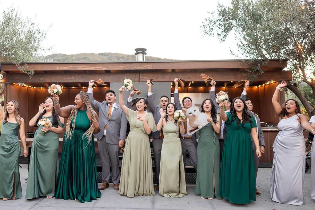 entire wedding party gathered and cheering for the bride and groom