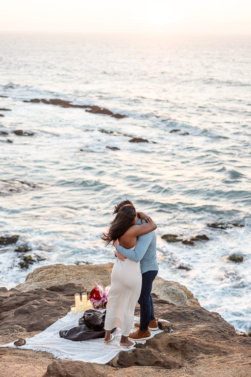 couple embracing with the wide ocean below them