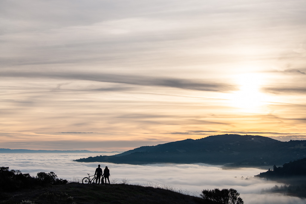 faraway shot of trail biking couple and dog