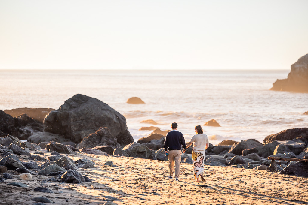 couple walking along the beach into the sunset