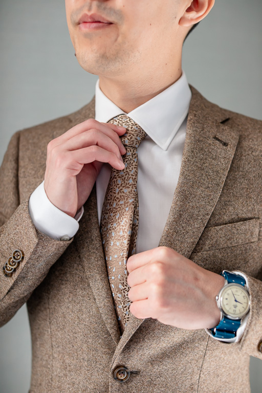 groom looking like a model adjusting his tie
