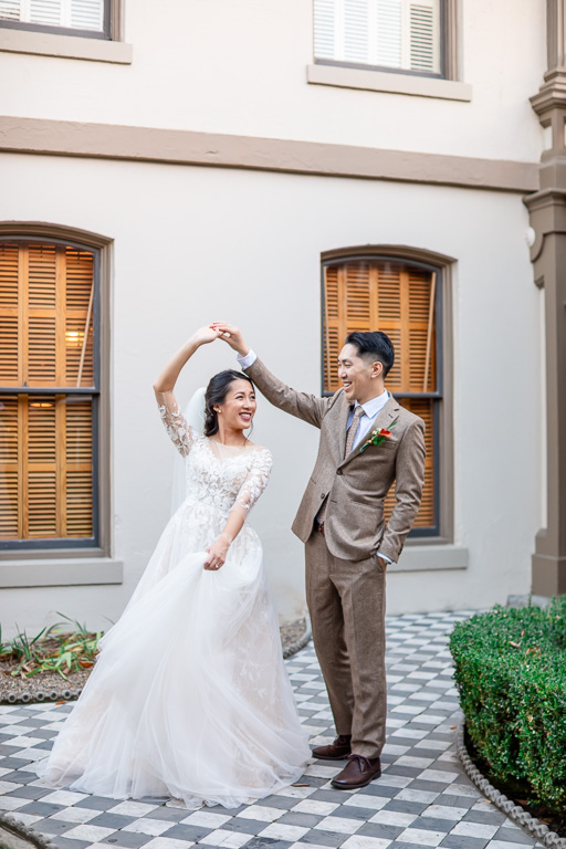 couple dancing on a checkerboard tile floor outside