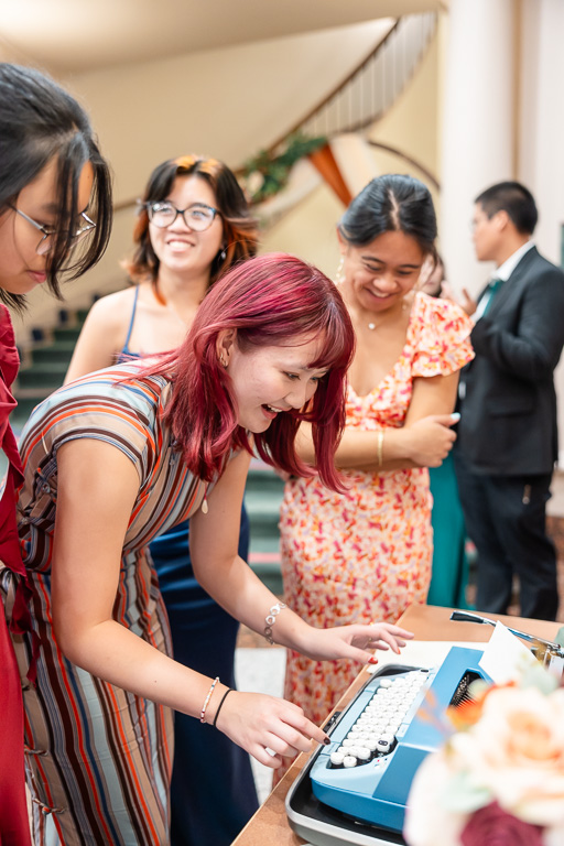 a wedding guest typing up a note for the newlyweds on a classic typewriter