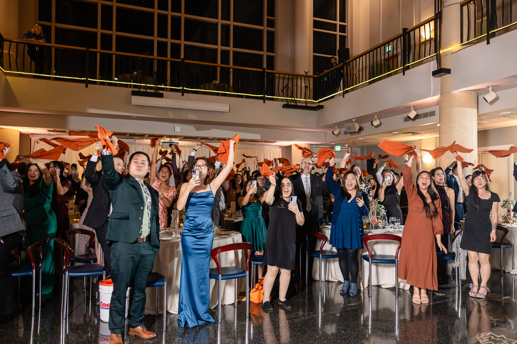 guests cheering and waving handkerchiefs around to welcome the bride and groom into their reception