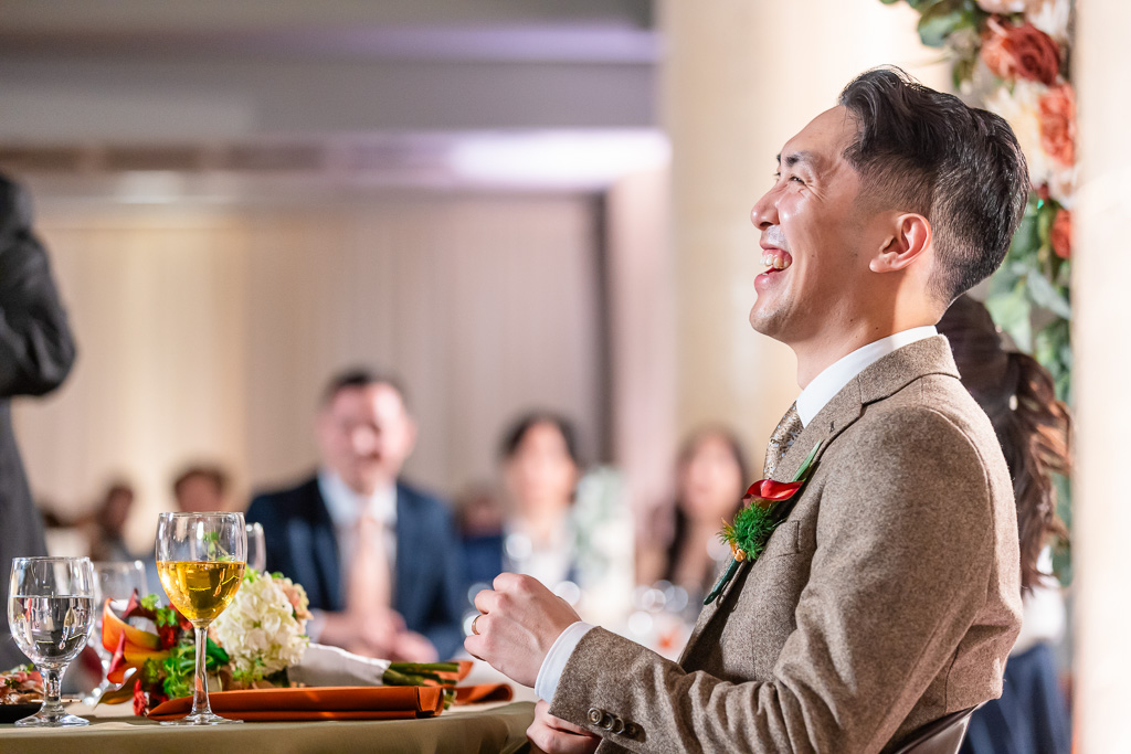 groom laughing out of embarassment during dinner toasts