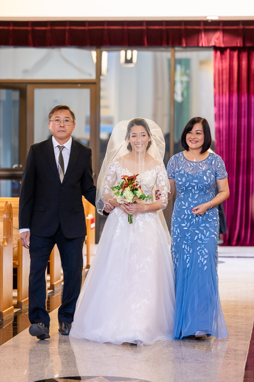 bride with her parents walking up the aisle at Vietnamese Martyrs Church