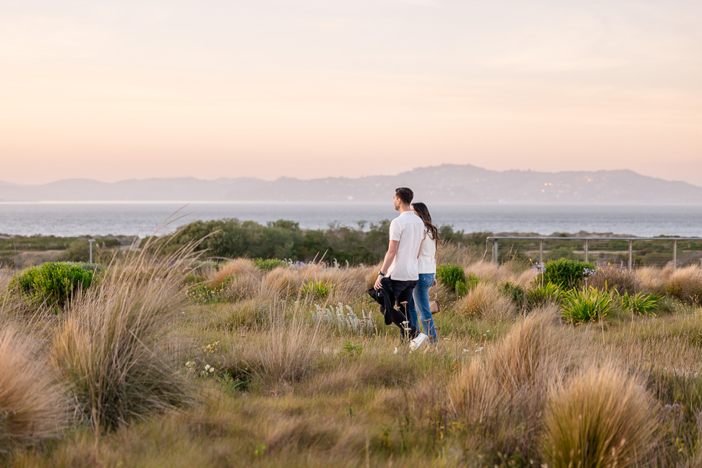 man and woman walking through fields of grass in the Presidio at sunset