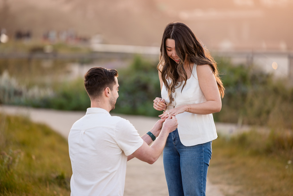 putting engagement ring on her finger