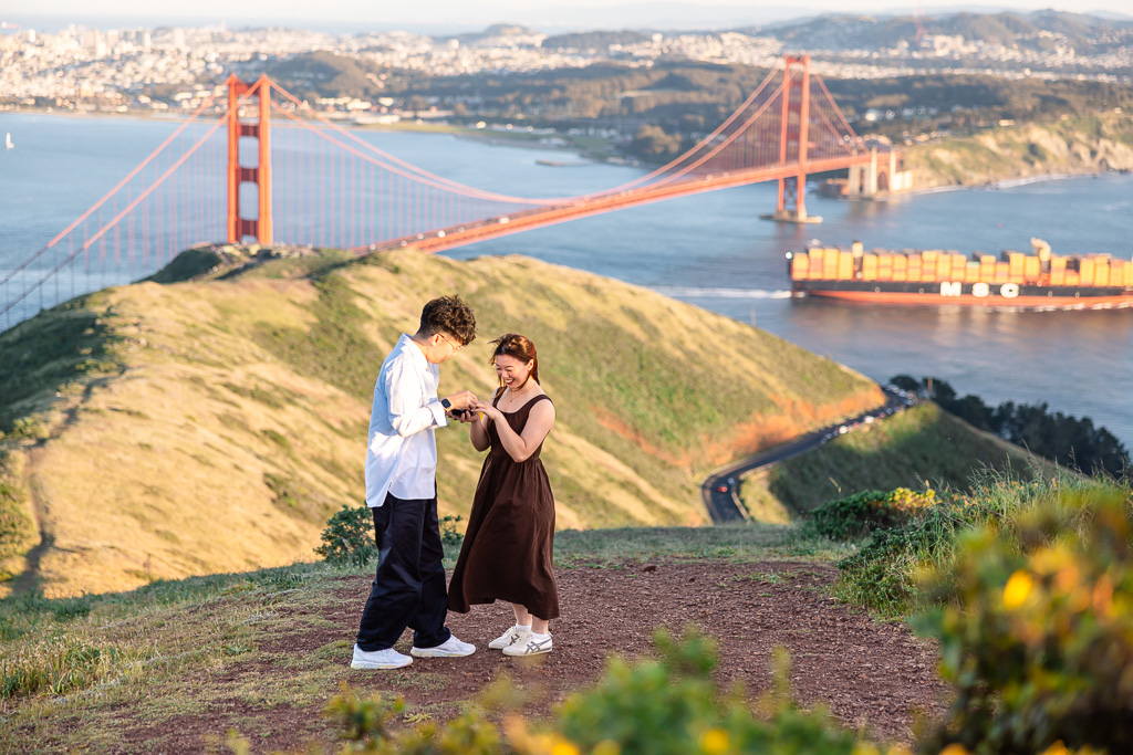 enjoying first moments as engaged couple as a container ship passes by