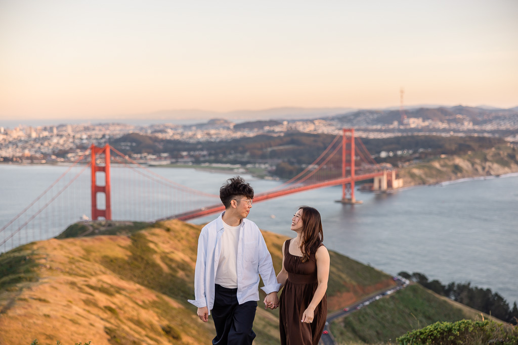 photo of couple on a mountaintop with the Golden Gate Bridge and San Francisco far below them