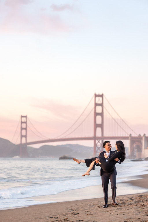 guy carrying girl on the beach for engagement photos