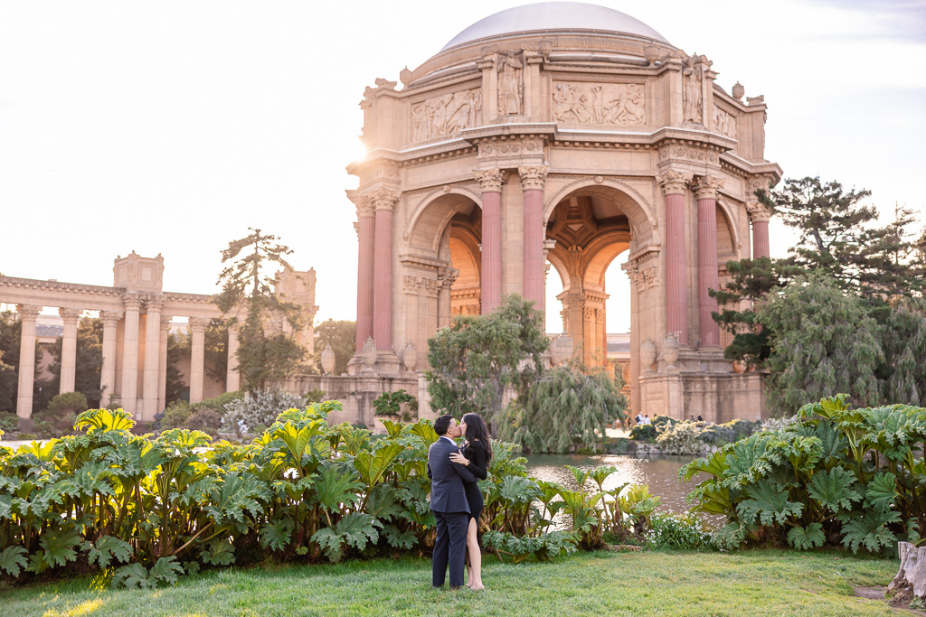 couple kissing with the Palace of Fine Arts in the background during golden hour