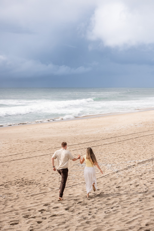 couple running off into the distance on the beach