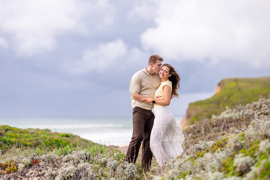 engagement photos on the flowers and grass near beach