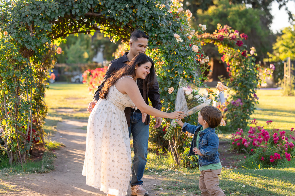 a little boy giving the bride-to-be a bouquet of flowers