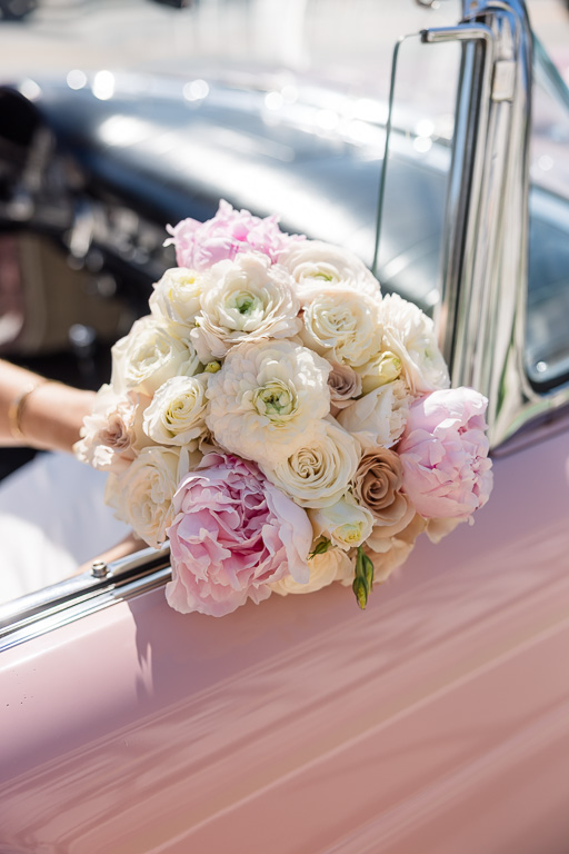 wedding bouquet on a pink classic car
