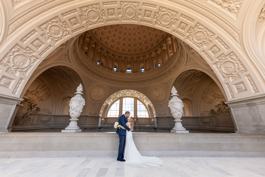 grand wide angle shot of wedding couple at SF City Hall balcony