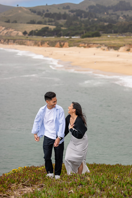 engagement photos of couple on a hill above the beach
