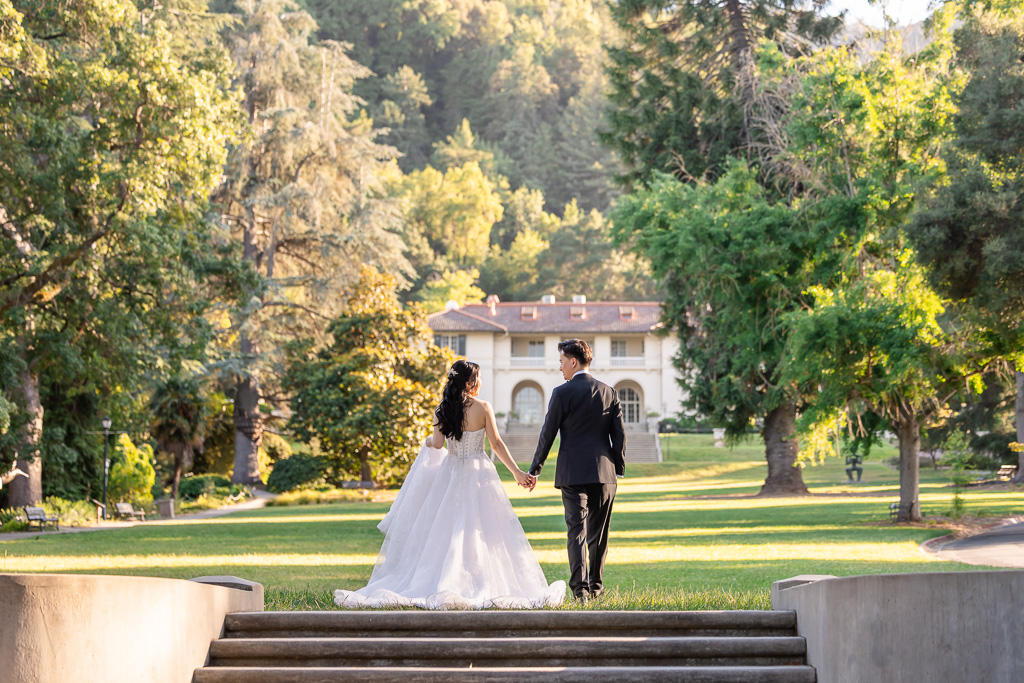 bride and groom walking towards Villa Montalvo and away from the camera right after wedding ceremony