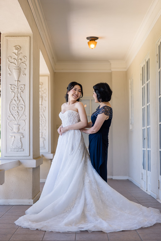 mom with bride in her wedding dress