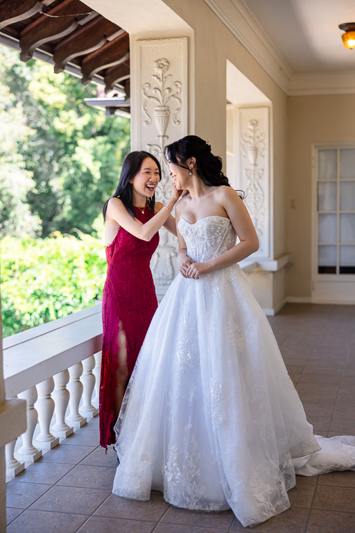 bride's best friend helping her with her dress and jewelry