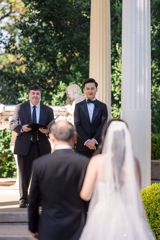 groom looking at the bride and her dad during the wedding processional