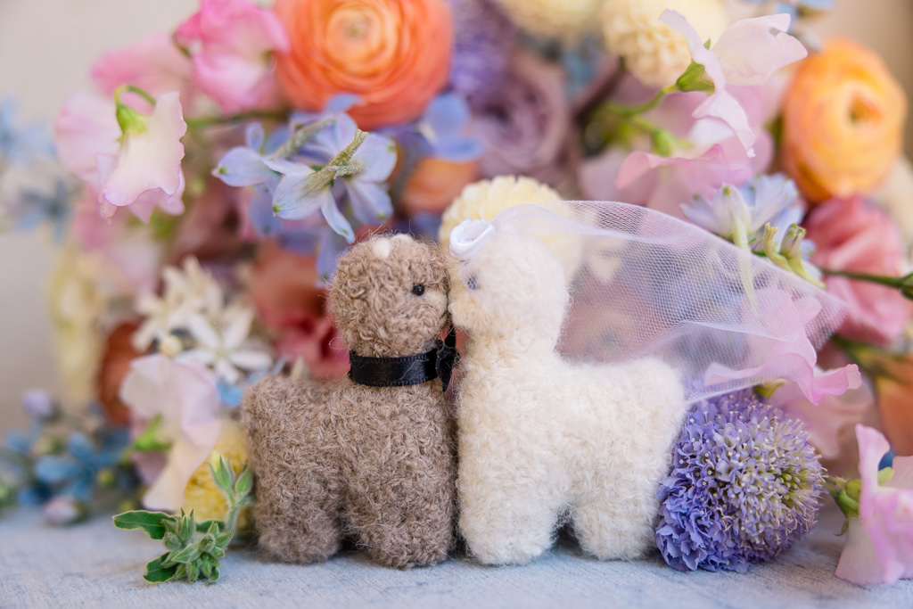 a pair of stuffed alpacas kissing