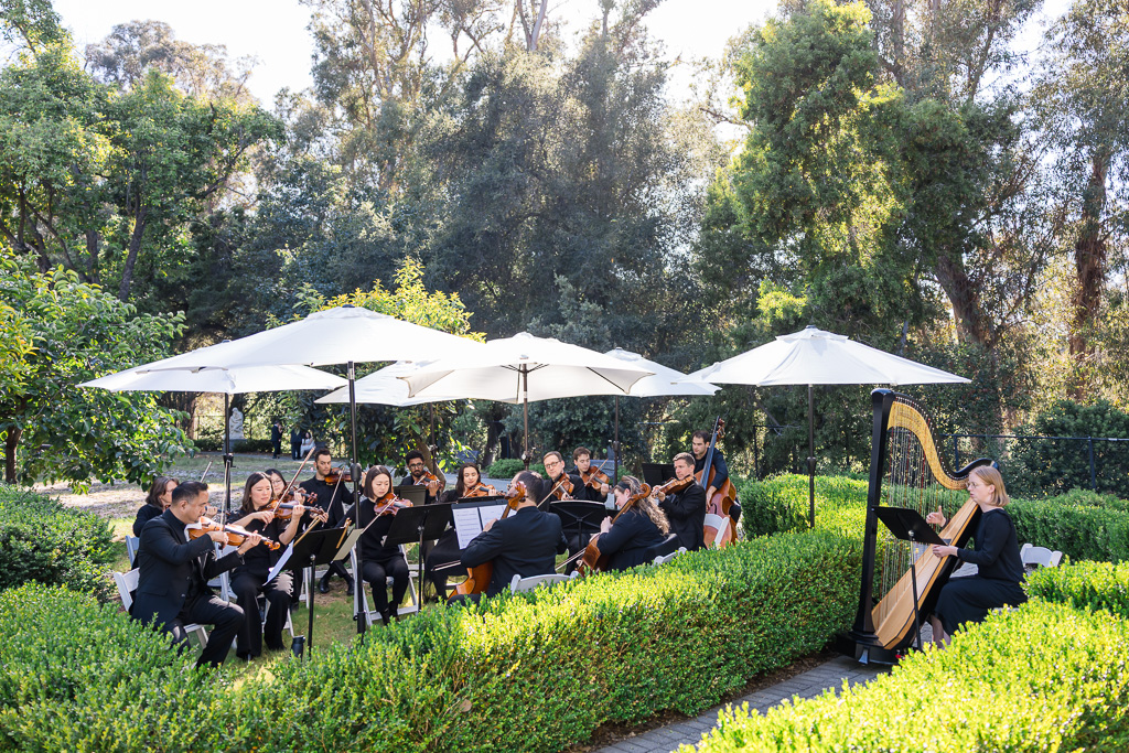 15-person string ensemble performing during wedding ceremony at Villa Montalvo in the Italianate Garden