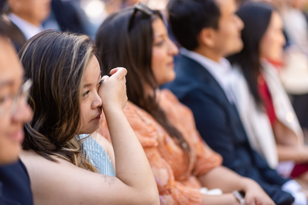 a friend wiping away a tear during a touching vow exchange